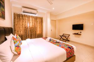 um quarto de hotel com uma cama e uma televisão em FabHotel Blossoms Service Apartment em Chennai