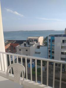 a white chair sitting on a balcony overlooking the ocean at Apartamento Playero in Cartagena de Indias