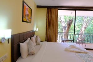 A bed or beds in a room at The Byke Royal Pearl Anjuna