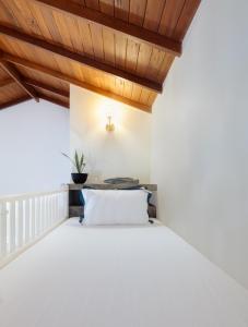 a bed in a room with a wooden ceiling at Green Escape Unawatuna in Unawatuna