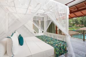 a bedroom with a white bed with a canopy at Green Escape Unawatuna in Unawatuna
