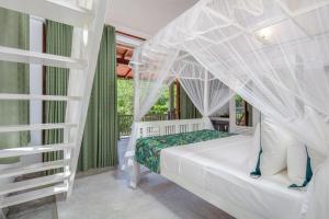a bedroom with a white bed with a canopy at Green Escape Unawatuna in Unawatuna