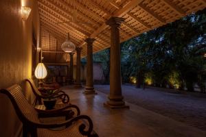 a porch with two chairs and a table and lights at Green Escape Unawatuna in Unawatuna