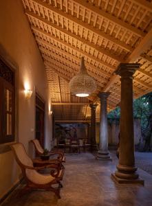 a porch with chairs and a ceiling with a chandelier at Green Escape Unawatuna in Unawatuna