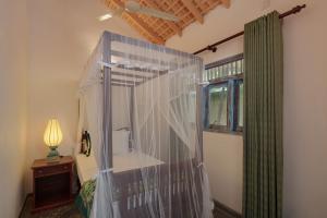 a bedroom with a canopy bed and a window at Green Escape Unawatuna in Unawatuna