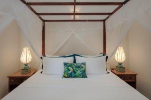 a bedroom with a bed with two lamps on tables at Green Escape Unawatuna in Unawatuna