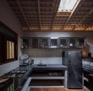 a kitchen with a sink and a refrigerator at Green Escape Unawatuna in Unawatuna