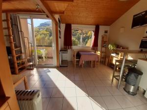 a living room with a view of a kitchen and a table at Appartement situation idéale Briançon tout confort in Briançon