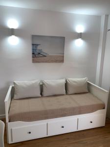 a bed in a room with two lights on the wall at FANTASTIC APARTMENT. LOS CRISTIANOS. FREE WIFI. in Los Cristianos