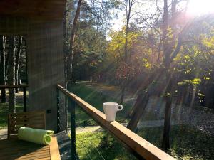 a coffee cup sitting on a railing on a porch at 3pokoje - domek pod lasem na odludziu in Susiec