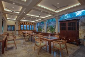 a restaurant with wooden tables and chairs and a fireplace at Green Escape Unawatuna in Unawatuna