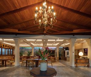 a dining room with a chandelier hanging from a wooden ceiling at Green Escape Unawatuna in Unawatuna
