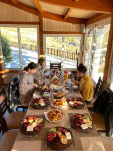 斯庫台的住宿－Bujtina e Muriqit，一群人坐在桌子旁吃着食物