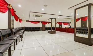 a banquet hall with red drapes and chairs at Treebo Trend Mohit Regency in Bhopal