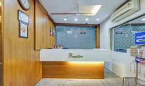 a reception counter in a store with a clock on the wall at Treebo Trend Mohit Regency in Bhopal