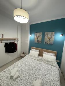 sypialnia z dużym łóżkiem i niebieską ścianą w obiekcie 1BD - Deer Traveler Central Apt w Salonikach