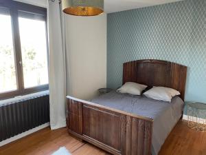 a bedroom with a large wooden bed in a room at Maison chaleureuse in Villeneuve-sur-Lot