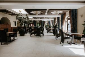 a dining room with tables and chairs and windows at Hotel Bonaparte in Košice