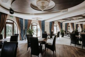 a dining room with tables and chairs and windows at Hotel Bonaparte in Košice