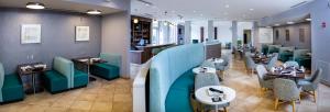 a restaurant with blue chairs and tables and a restaurant at Holiday Inn Statesboro-University Area by IHG in Statesboro