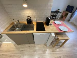 een keuken met een wastafel en een bureau met een toetsenbord bij Place de Metz, Hyper-centre Grenoble, Studio 25 m2 in Grenoble