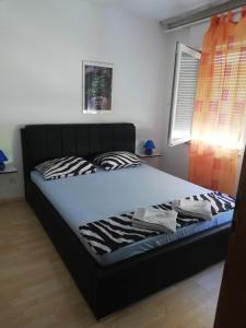 łóżko w sypialni z czarnym łóżkiem w obiekcie Villa Elit w mieście Dugi Rat