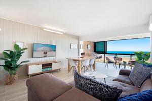 uma sala de estar com um sofá e uma mesa em Absolutly Beachfront Surfers Paradise, Pure Shores! em Gold Coast