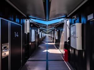 Un pasillo de un tren con luces azules. en HOTEL R9 The Yard Uruma, en Uruma