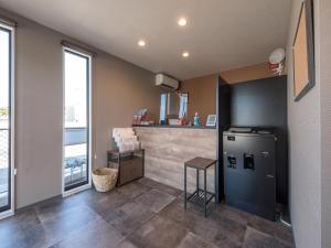 a kitchen with a refrigerator and a counter at HOTEL R9 The Yard Uruma in Uruma