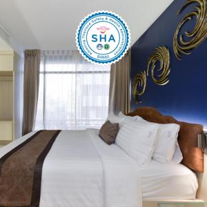 a bedroom with a large bed with a blue wall at Aspira G Sukhumvit 33 in Bangkok