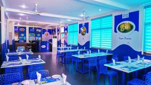 a dining room with blue tables and blue chairs at KTDC Ripple Land, Alappuzha in Alleppey