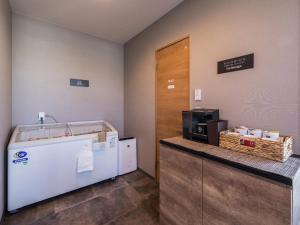 een kamer met een aanrecht met een koffiezetapparaat en een magnetron bij HOTEL R9 The Yard Uruma in Uruma