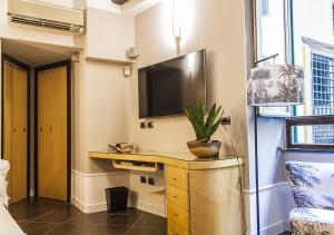 ナポリにあるRelais Santa Chiaraのデスク、壁掛けテレビが備わる客室です。