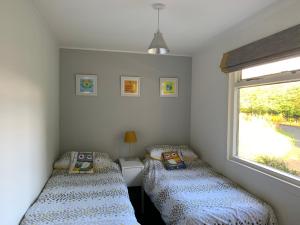 two twin beds in a room with a window at Creity Hall Chalet in Stirling