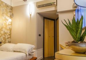 a bedroom with a bed and a table with a plant at Relais Santa Chiara in Naples