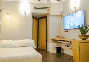 1 dormitorio con 1 cama y TV de pantalla plana en Relais Santa Chiara, en Nápoles