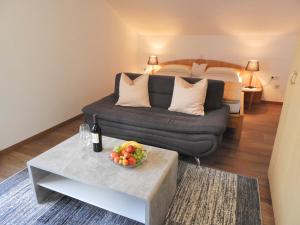 a living room with a couch and a table with a bowl of fruit at Appartements Hirsch in Bad Birnbach