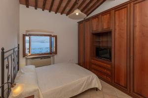a bedroom with a bed and a cabinet and a window at HelloElba Appartamento Il Faro 2 in Portoferraio