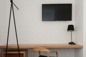 ein Flachbildfernseher an einer Wand mit einem Holztisch in der Unterkunft Ereza Hoopoe Villas in Playa Blanca