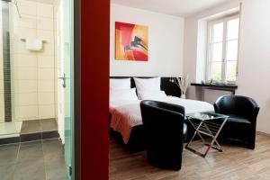 シュヴェツィンゲンにあるVilla Bassermannのベッドルーム1室(ベッド1台、椅子2脚、テーブル付)