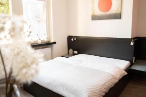 ein Bett mit einem schwarzen Kopfteil in einem Schlafzimmer in der Unterkunft Villa Bassermann in Schwetzingen