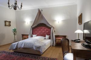 a bedroom with a canopy bed and a desk at Schloss Gerzen in Gerzen