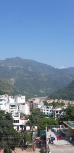a city with buildings and mountains in the background at MANIK GUEST HOUSE in Rishīkesh