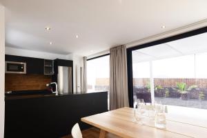 a kitchen with a wooden table and a large window at Duna Colorada 6 in Lajares +13 photos