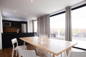 a dining room with a wooden table and white chairs at Duna Colorada 6 in Lajares