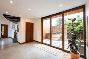 ein Wohnzimmer mit großen Glastüren und einer Topfpflanze in der Unterkunft Modern indoor-outdoor living wHot Tub Walk to Beaches & Mountain Trails in Montara