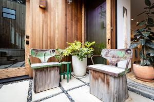 twee stoelen en een tafel op een veranda met planten bij Modern indoor-outdoor living wHot Tub Walk to Beaches & Mountain Trails in Montara