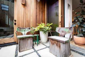 2 Stühle und ein Tisch auf einer Veranda mit Pflanzen in der Unterkunft Modern indoor-outdoor living wHot Tub Walk to Beaches & Mountain Trails in Montara