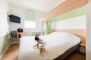 een slaapkamer met een bed met een laptop erop bij ibis budget Carcassonne Aéroport - A61 in Carcassonne