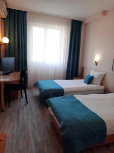 ガブロヴォにあるHotel Balkanのベッド3台とデスクが備わるホテルルームです。